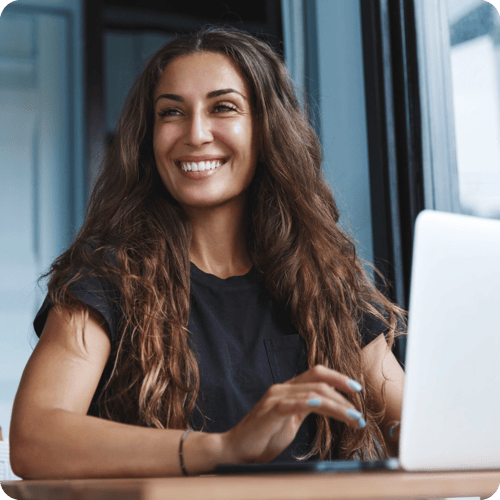 Smiling Woman Infront Of Her Laptop