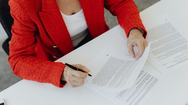 Woman in red jacket completing paperwork