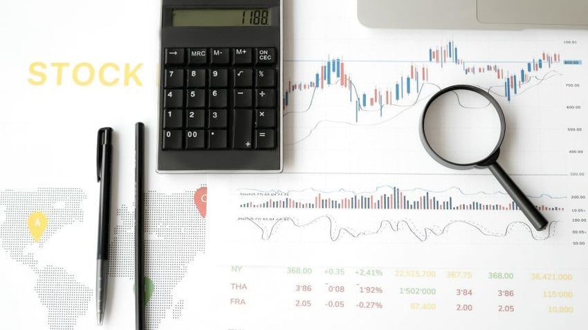 Calculator, pens, magnifying glass, stock report