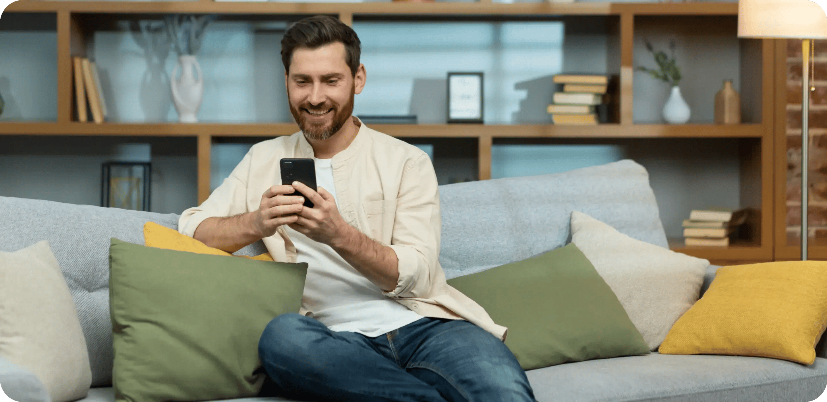young-smiling-man-sitting-on-sofa-at-home-during-q-2023-11-27-05-03-45-utc 1-2
